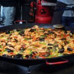 delicious paella with mollusks in big frying pan