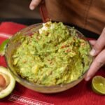 person making guacamole