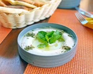 white ceramic bowl with yogurt and mint leaves