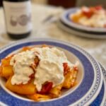 Piatto di paccheri al pomodoro con stracciatella e burro montato alle acciughe del Cantabrico